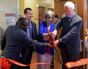 People cutting red ribbon for the grand opening of a new business