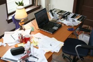 A cluttered desk with a computer

Description automatically generated