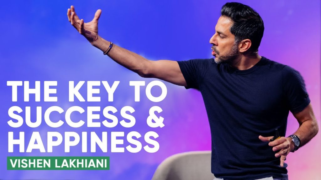 Vishen Lakhiani on stage mentoring millions of people with the words the key success and happiness